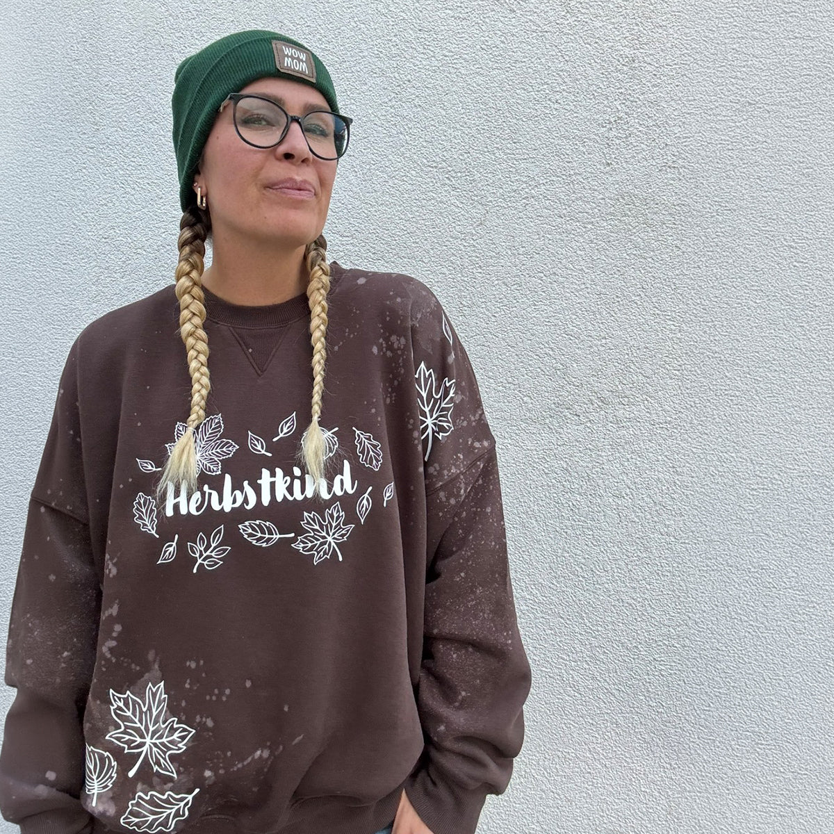 Herbstkind Plotterdatei – weißer Plot auf braunem, gesprenkelt gebleichtem Sweater mit Blättern auf den Ärmeln, dazu grüne Mütze mit WOW-MOM-Patch