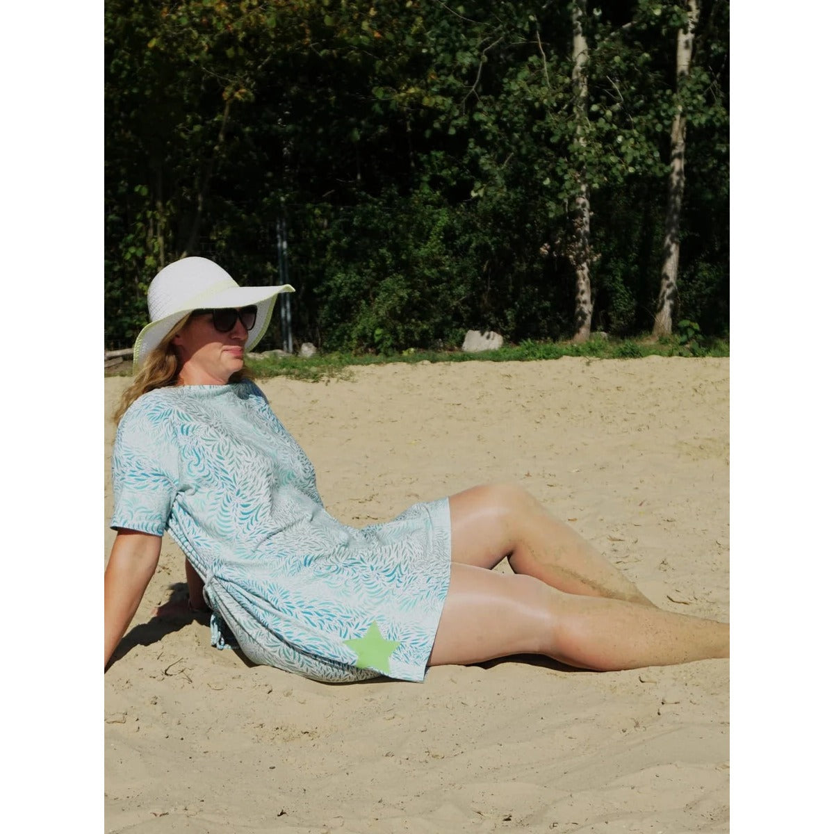 Cut Out Kleid Schnittmuster – Frau im hellen Cut Out Kleid im Gras sitzend (genähtes Designbeispiel)