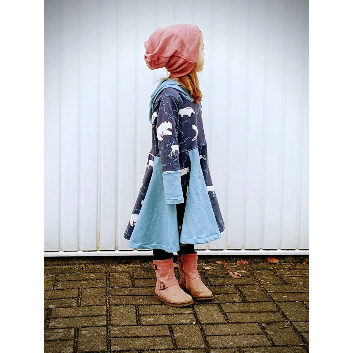 WinterWUNDERkleid Schnittmuster – Mädchen im hellblauen Winterwunderkleid mit Stiefeln (genähtes Designbeispiel)