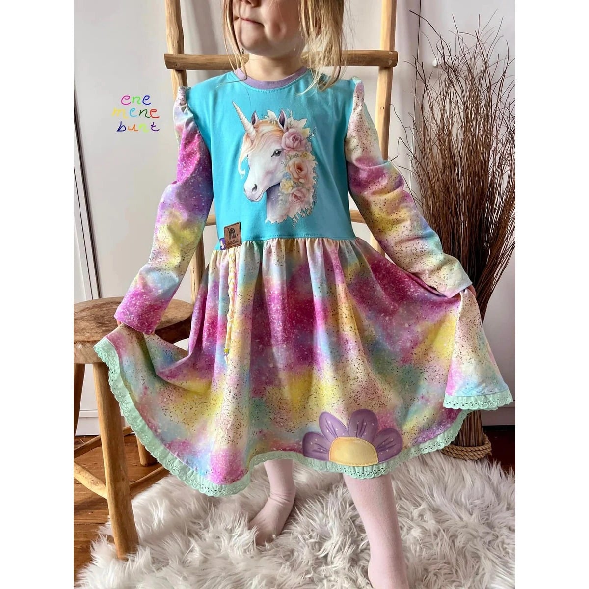 Winterzauberkleid Schnittmuster – Mädchen im bunten Winterzauberkleid mit Einhorn-Motiv (genähtes Designbeispiel)