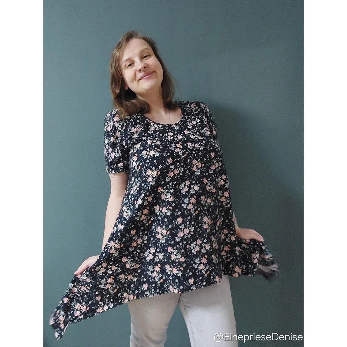 Sweet Mama Tunika Schnittmuster – Frau in schwarzer geblümter Tunika mit Zipfelsaum (genähtes Designbeispiel)