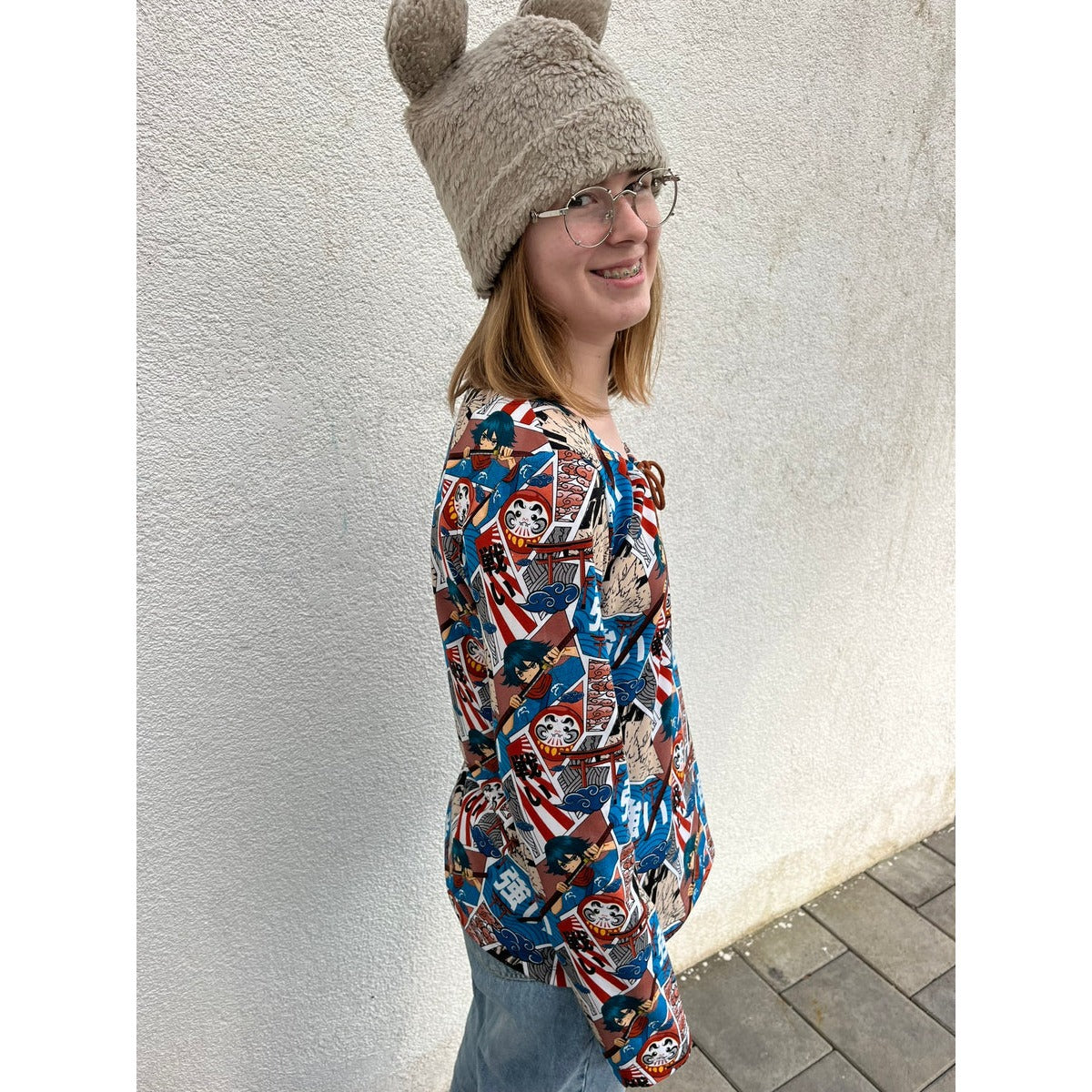 Miss Talia Schnittmuster – Frau mit Mütze in dunkler geblümter Bluse (genähtes Designbeispiel)