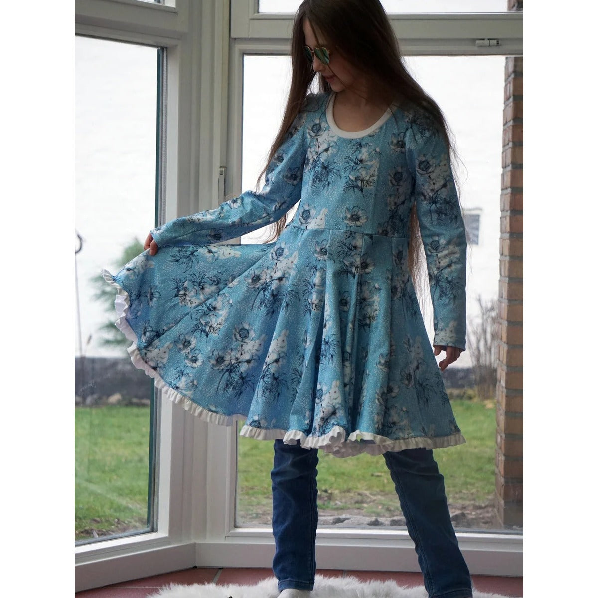 WinterWUNDERkleid Schnittmuster – Mädchen im blauen Winterwunderkleid drehend (genähtes Designbeispiel)