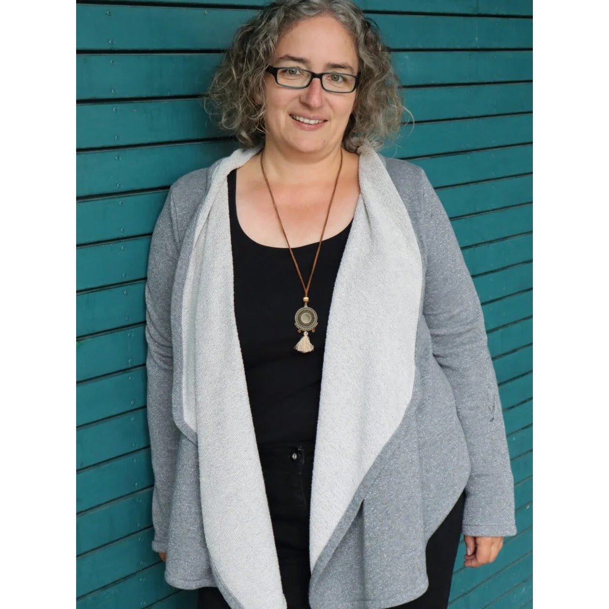 Zipfeljacke Sue Schnittmuster – Frau in grauer Zipfeljacke mit schwarzem Oberteil (genähtes Designbeispiel)