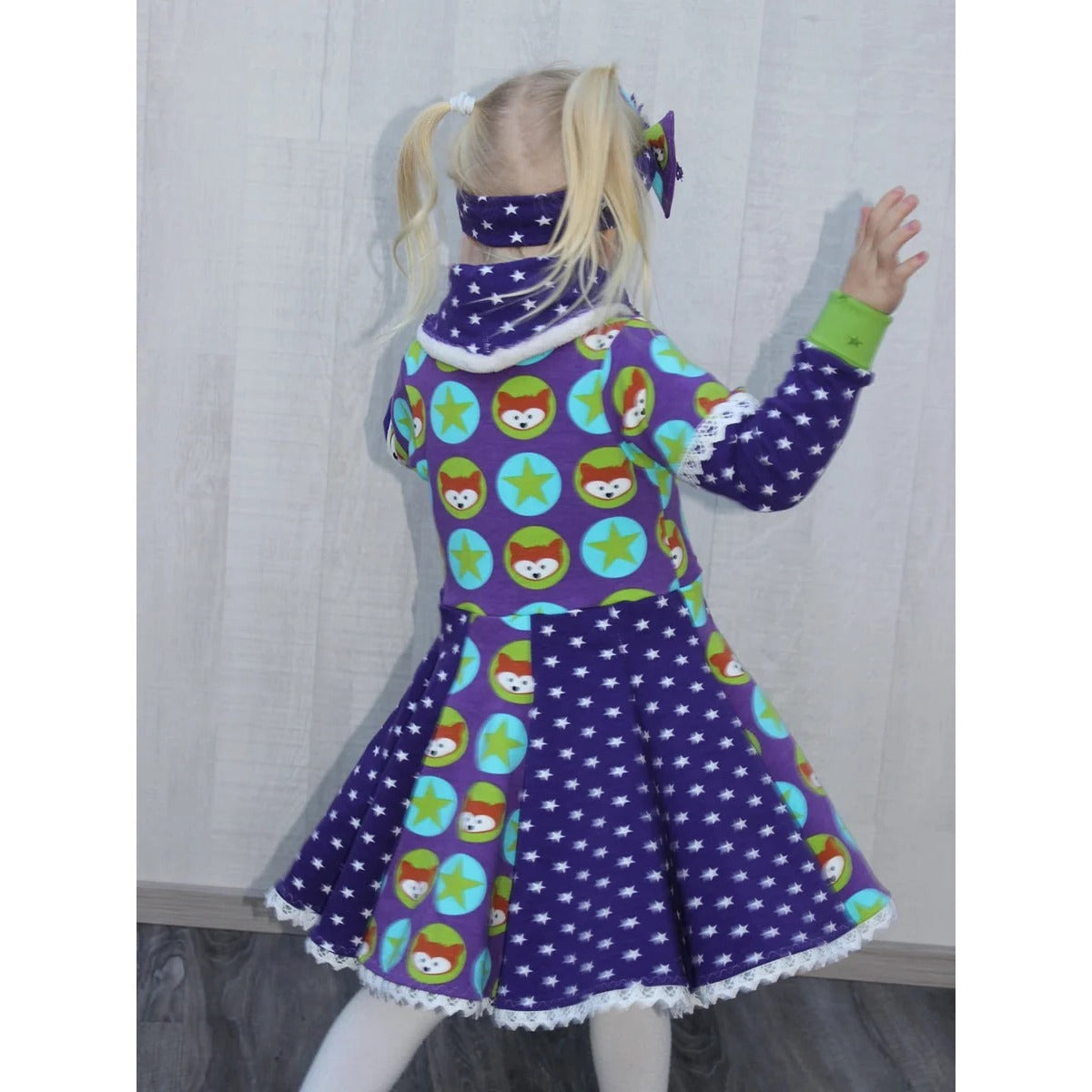 WinterWUNDERkleid Schnittmuster – Mädchen im lila Winterwunderkleid, Seitenansicht (genähtes Designbeispiel)