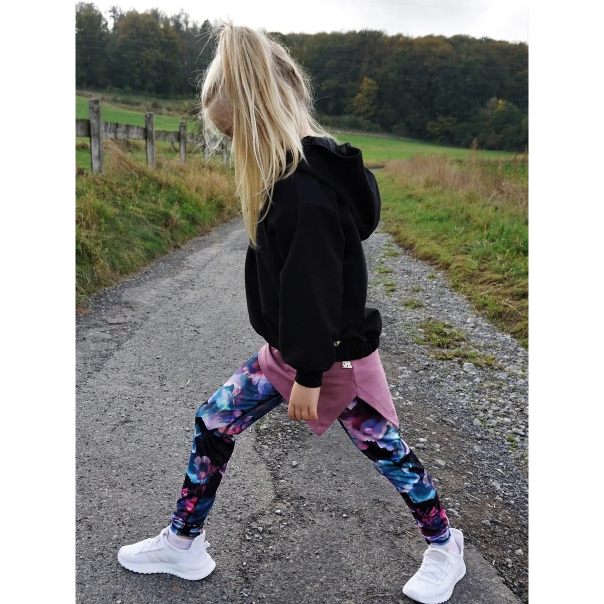 Oversized Pulli Schnittmuster – Mädchen im schwarzen Oversized-Pulli mit bunter Leggings (genähtes Designbeispiel)