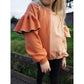 Oversized Pulli Schnittmuster – Mädchen im apricotfarbenen Oversized-Pulli mit Volantärmeln (genähtes Designbeispiel)
