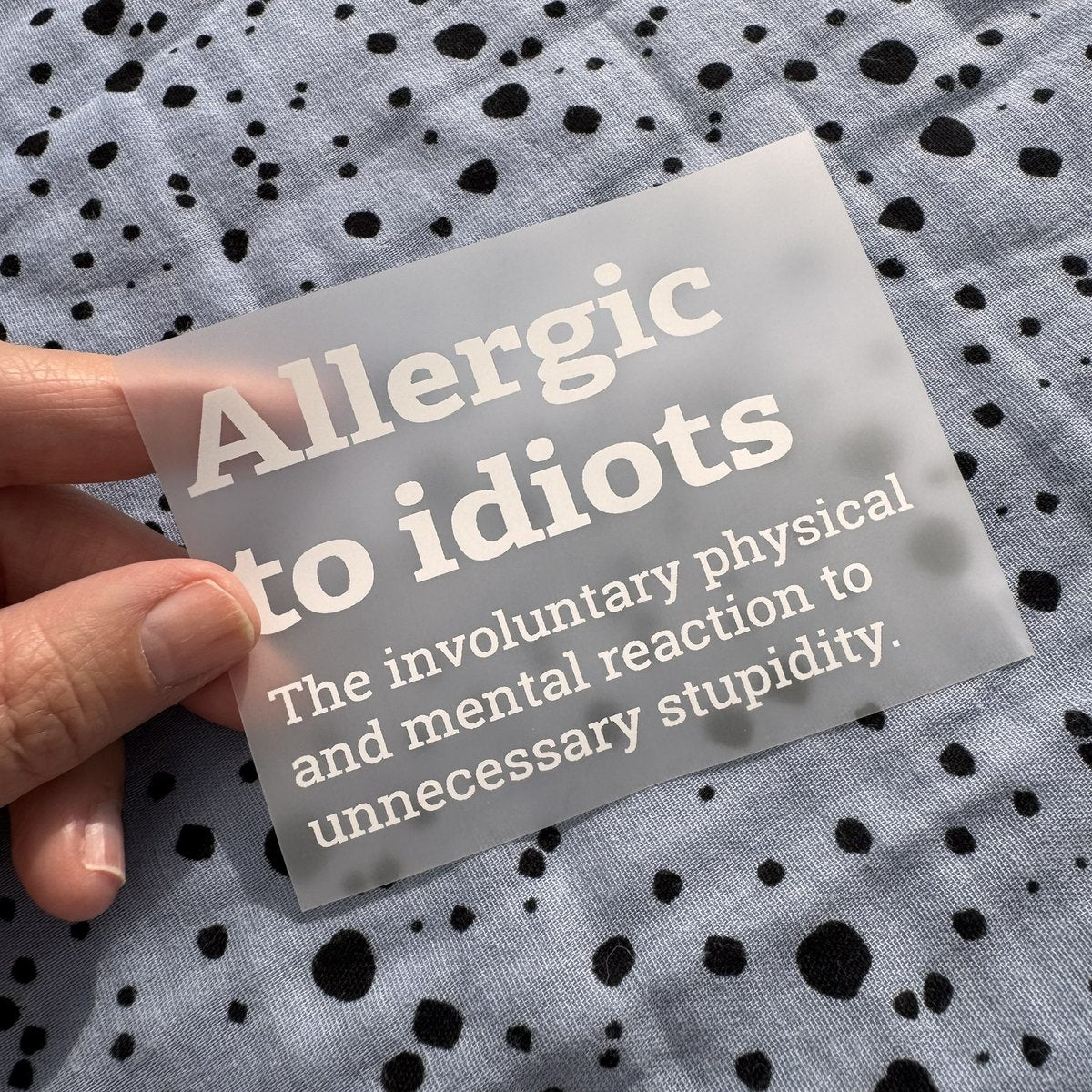 Bügelbild Allergic to idiots klein in Weiß, ca. 10 x 7 cm, in der Hand gehalten