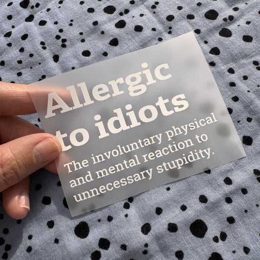 Bügelbild Allergic to idiots klein in Weiß, ca. 10 x 7 cm, in der Hand gehalten