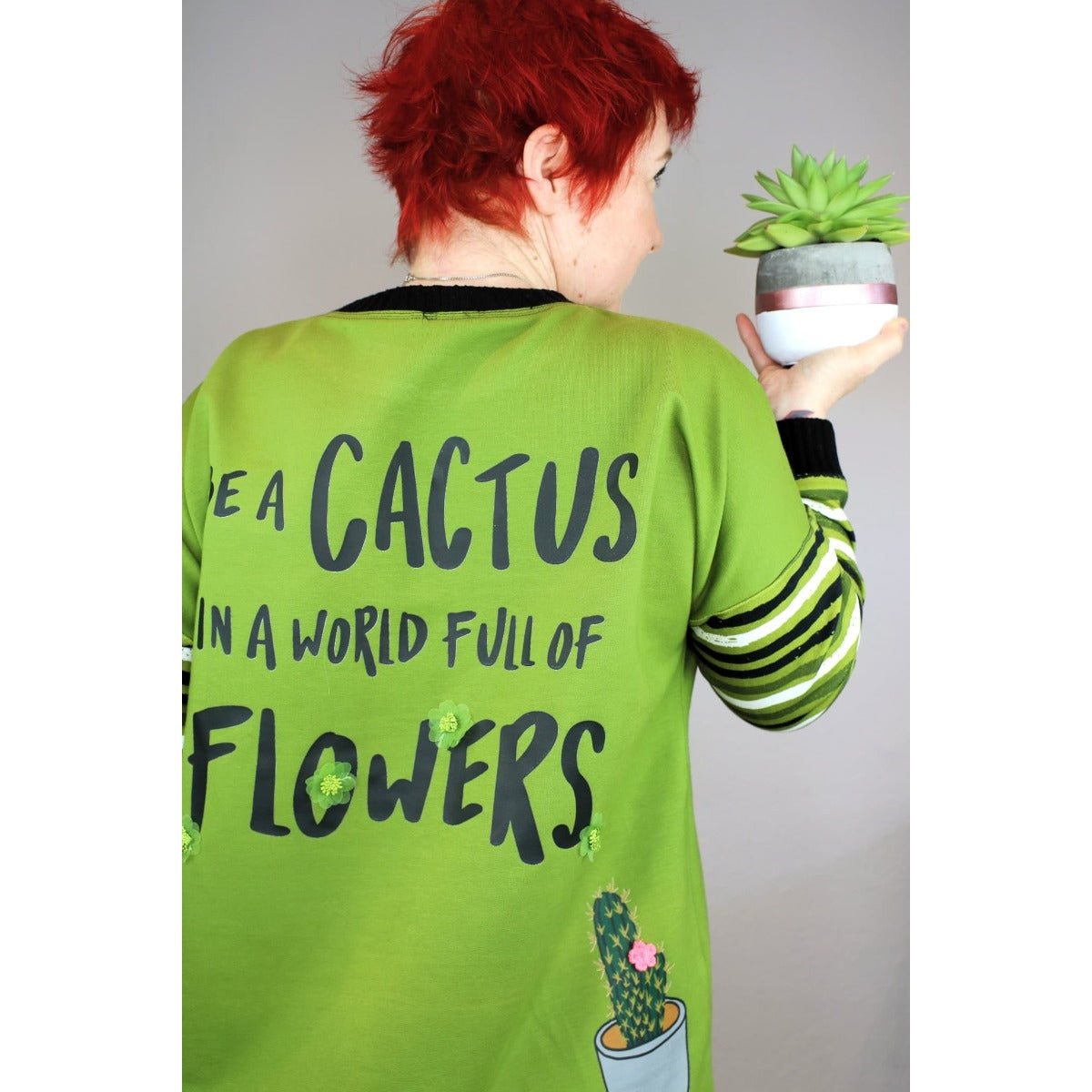 Bügelbild Be a cactus in Schwarz auf dem Rücken einer grünen Jacke (Beispielbild)