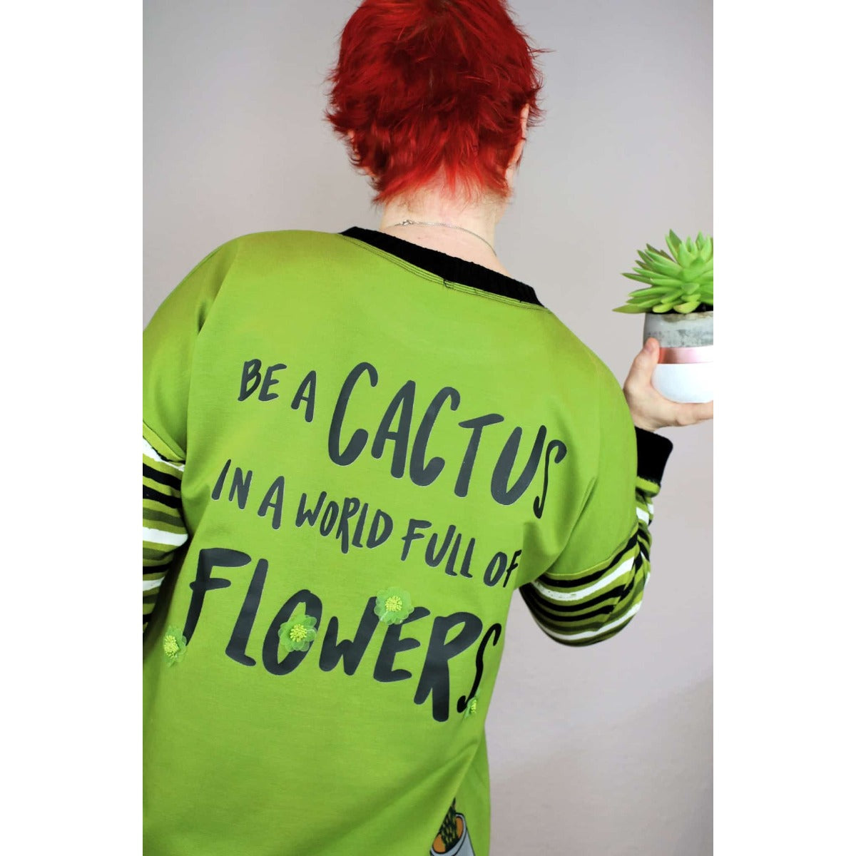 Bügelbild Be a cactus auf grüner Jacke, Rückansicht mit Kaktus in der Hand (Beispielbild)