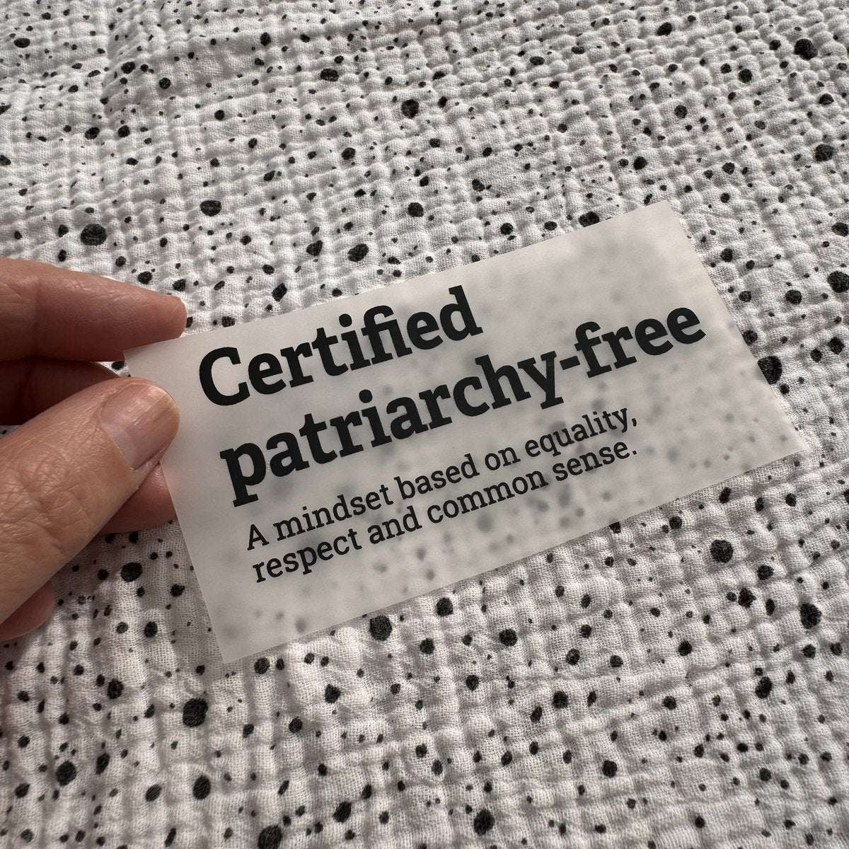 Bügelbild Certified patriarchy-free klein in Schwarz, ca. 10 x 4,5 cm, in der Hand gehalten