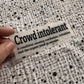 Bügelbild Crowd intolerant klein in Schwarz, ca. 10 x 3 cm, in der Hand gehalten