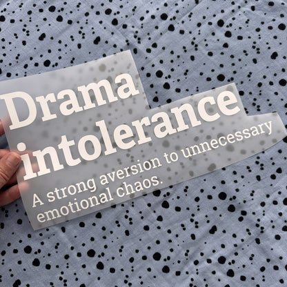 Bügelbild Drama intolerance groß in Weiß, ca. 29,5 x 15,5 cm, in der Hand gehalten