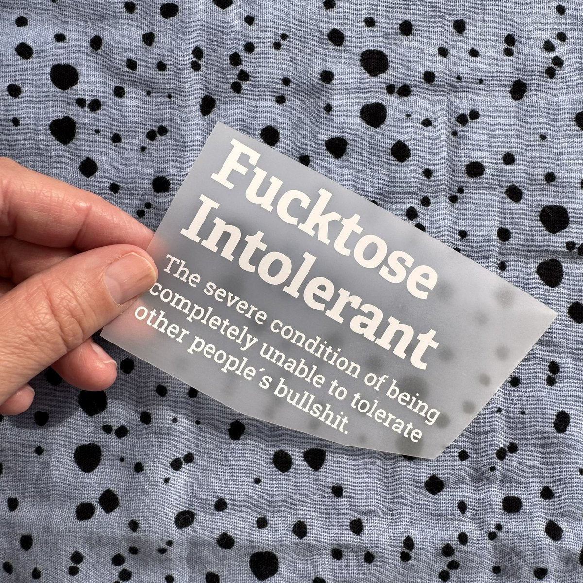 Bügelbild Fucktose Intolerant klein in Weiß, ca. 10 x 6,5 cm, in der Hand gehalten