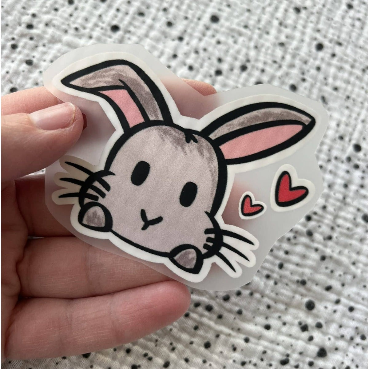 Bügelbild Hase mit Herz – Hasenkopf mit kleinen roten Herzen, in der Hand gehalten