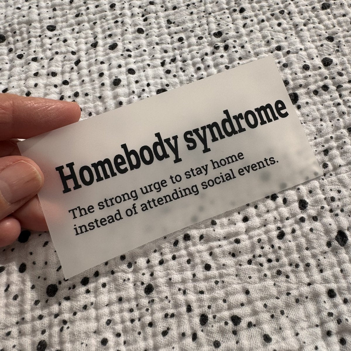 Bügelbild Homebody syndrome klein in Schwarz, ca. 9,5 x 3 cm, in der Hand gehalten