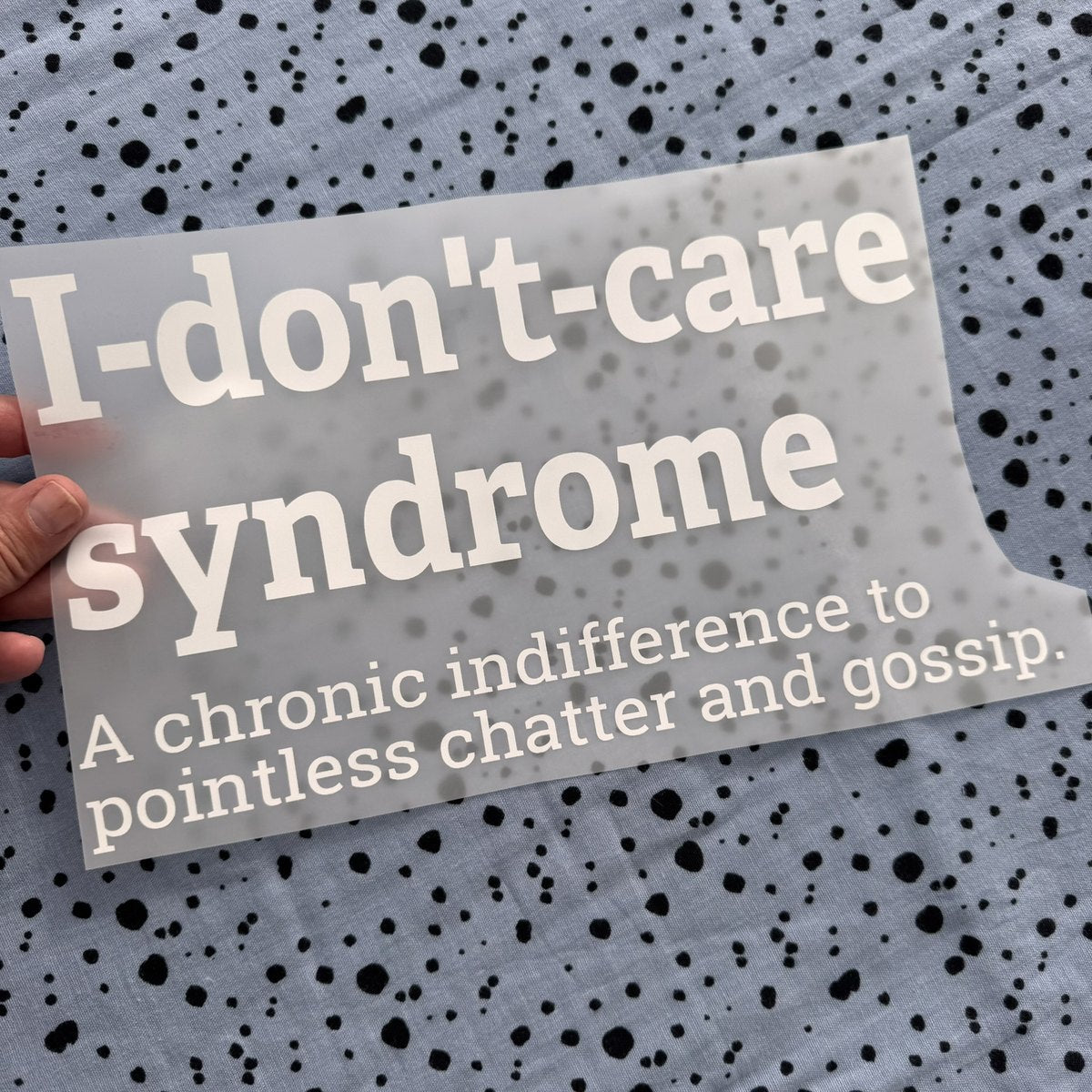 Bügelbild I-don't-care syndrome groß in Weiß, ca. 30 x 16,5 cm, in der Hand gehalten