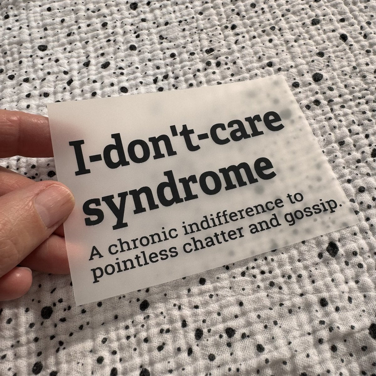 Bügelbild I-don't-care syndrome klein in Schwarz, ca. 10 x 5,5 cm, in der Hand gehalten