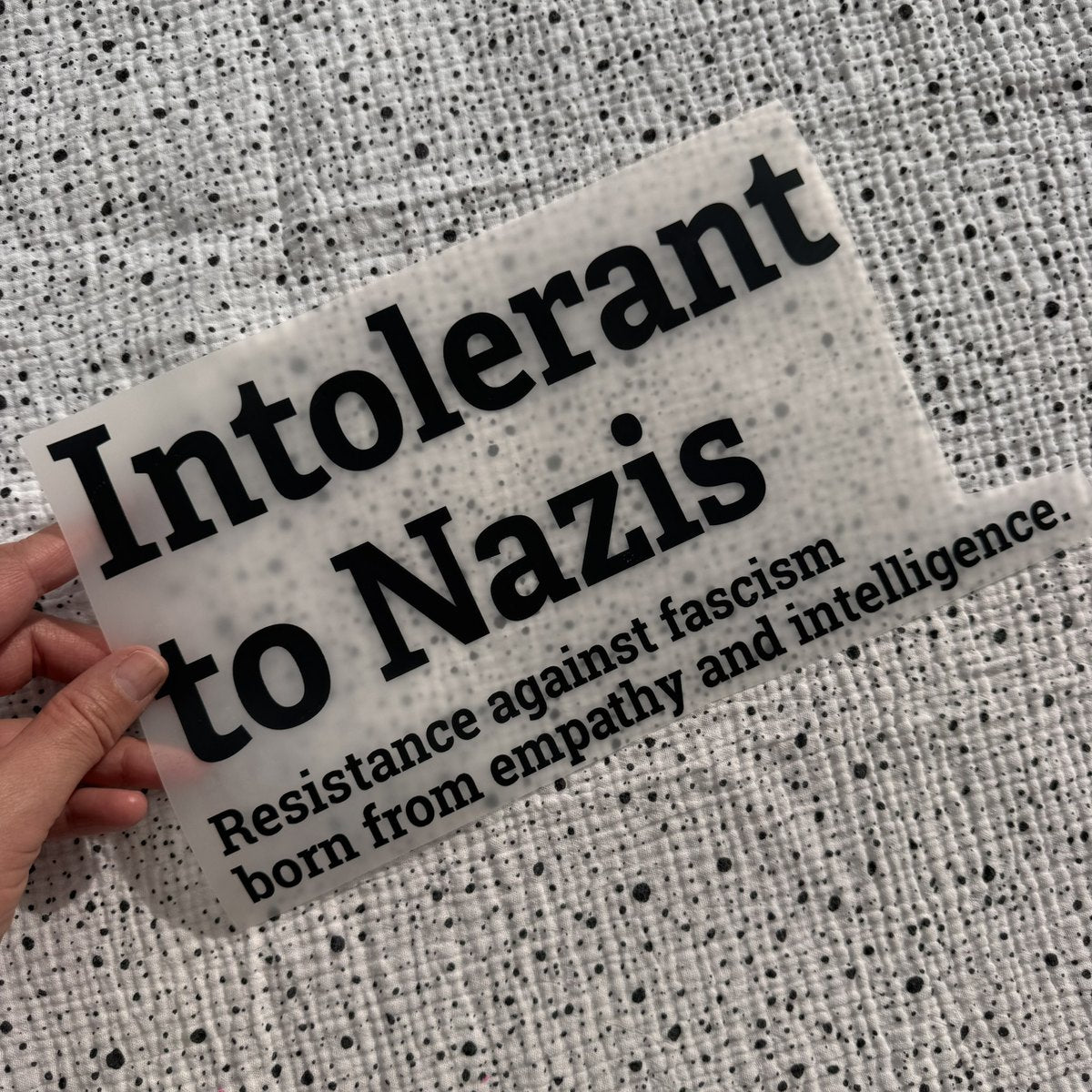 Bügelbild Intolerant to Nazis groß in Schwarz, ca. 30 x 16,5 cm, in der Hand gehalten