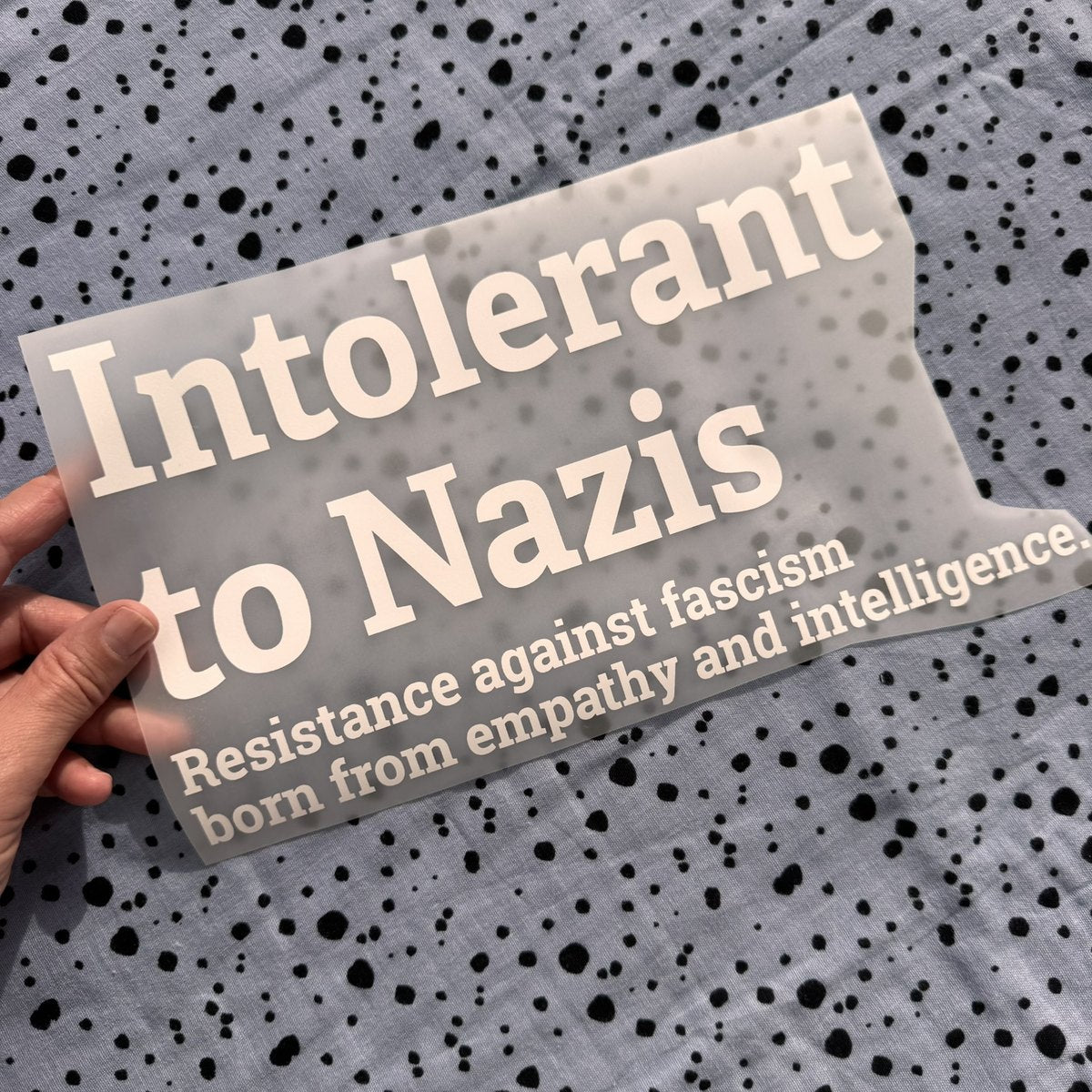 Bügelbild Intolerant to Nazis groß in Weiß, ca. 30 x 16,5 cm, in der Hand gehalten