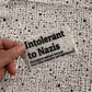 Bügelbild Intolerant to Nazis klein in Schwarz, ca. 10 x 5,5 cm, in der Hand gehalten