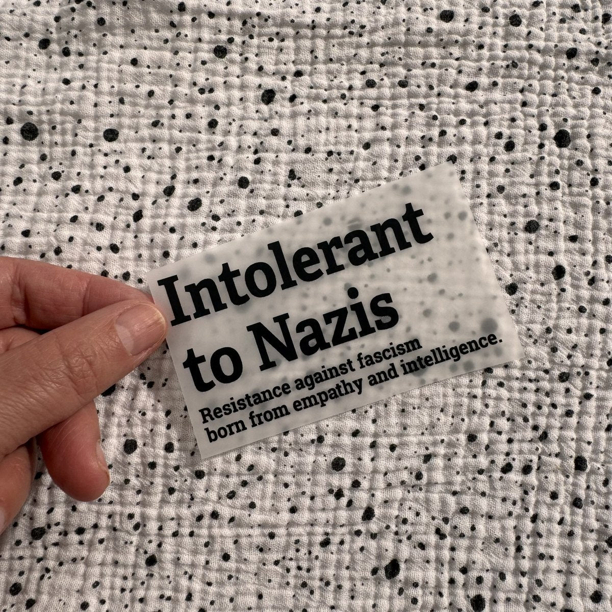 Bügelbild Intolerant to Nazis klein in Schwarz, ca. 10 x 5,5 cm, in der Hand gehalten