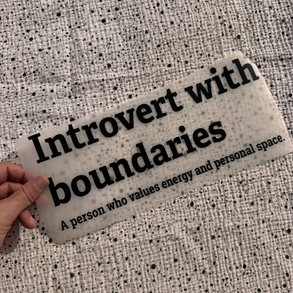 Bügelbild Introvert with boundaries groß in Schwarz, ca. 30 x 12 cm, in der Hand gehalten