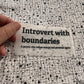 Bügelbild Introvert with boundaries klein in Schwarz, ca. 10 x 4 cm, in der Hand gehalten