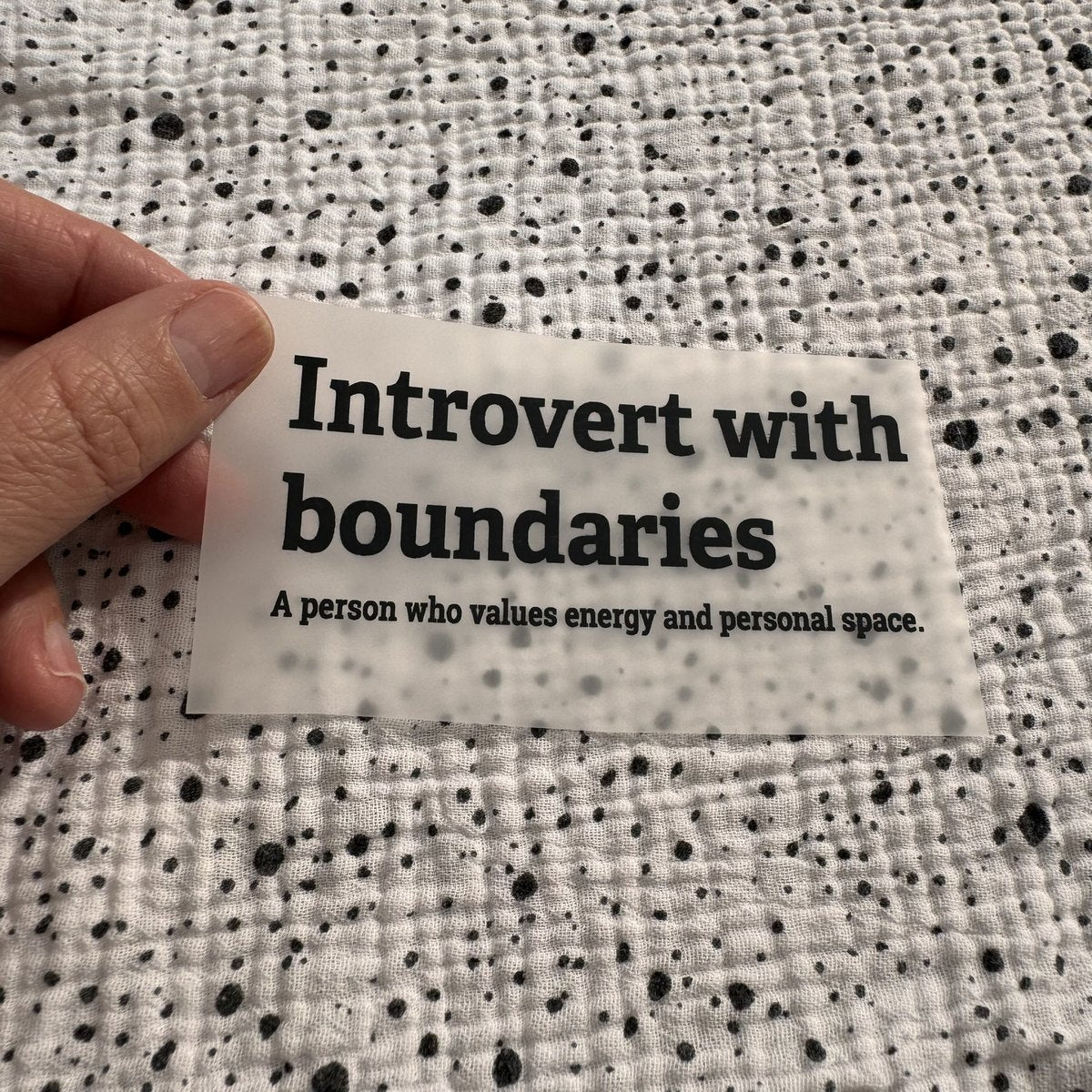 Bügelbild Introvert with boundaries klein in Schwarz, ca. 10 x 4 cm, in der Hand gehalten