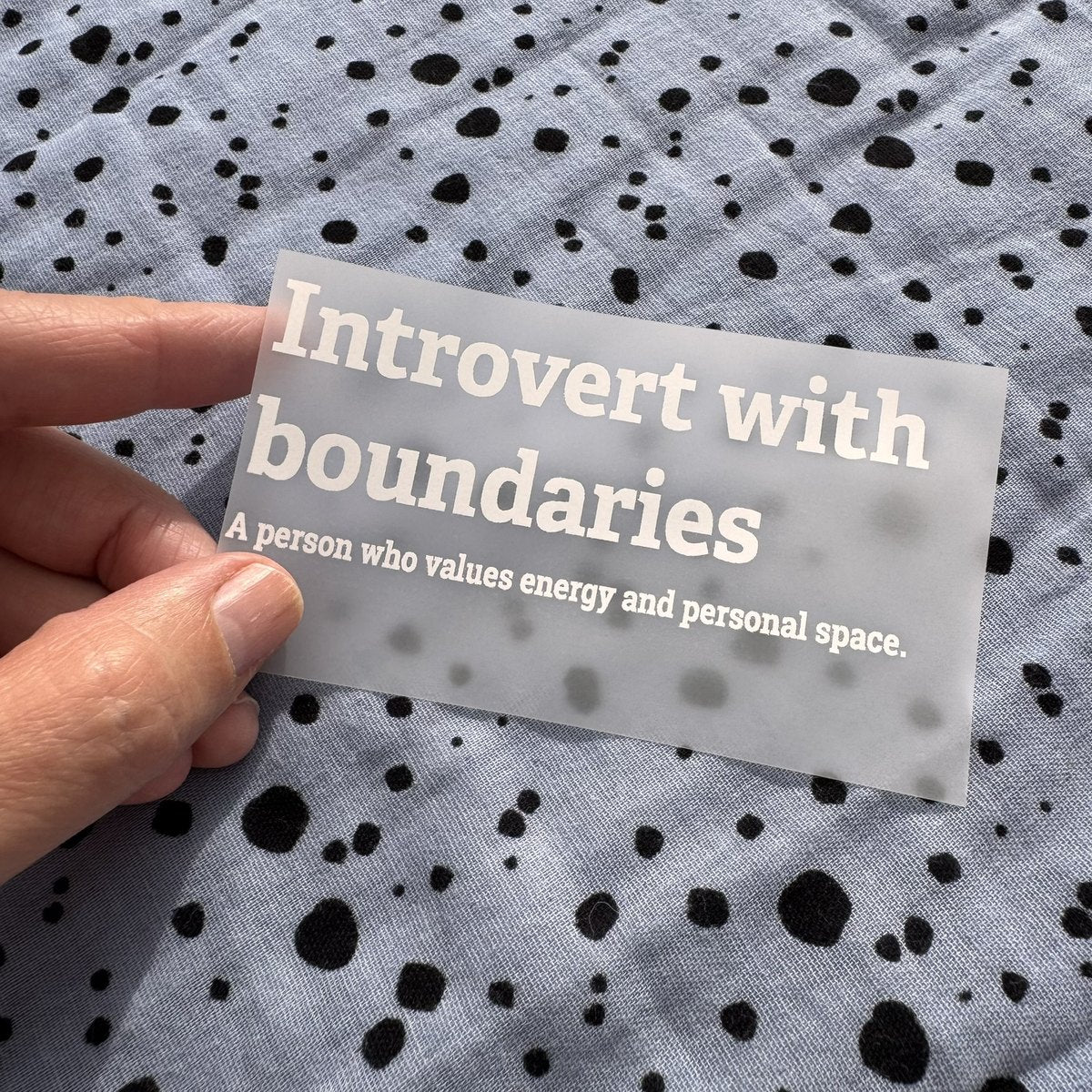 Bügelbild Introvert with boundaries klein in Weiß, ca. 10 x 4 cm, in der Hand gehalten