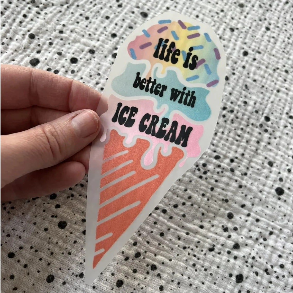 Bügelbild life is better with ice cream – Eiswaffel mit Schriftzug, in der Hand gehalten