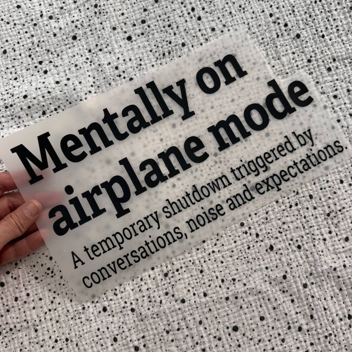 Bügelbild Mentally on airplane mode groß in Schwarz, ca. 30 x 16,5 cm, in der Hand gehalten