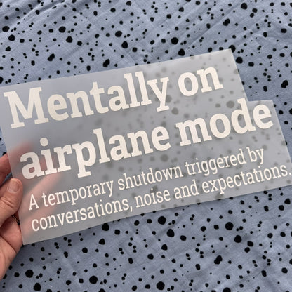 Bügelbild Mentally on airplane mode groß in Weiß, ca. 30 x 16,5 cm, in der Hand gehalten