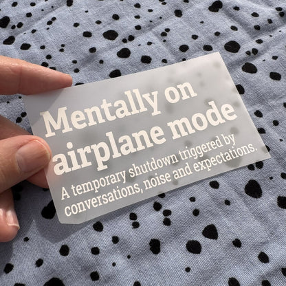 Bügelbild Mentally on airplane mode klein in Weiß, ca. 10 x 5,5 cm, in der Hand gehalten