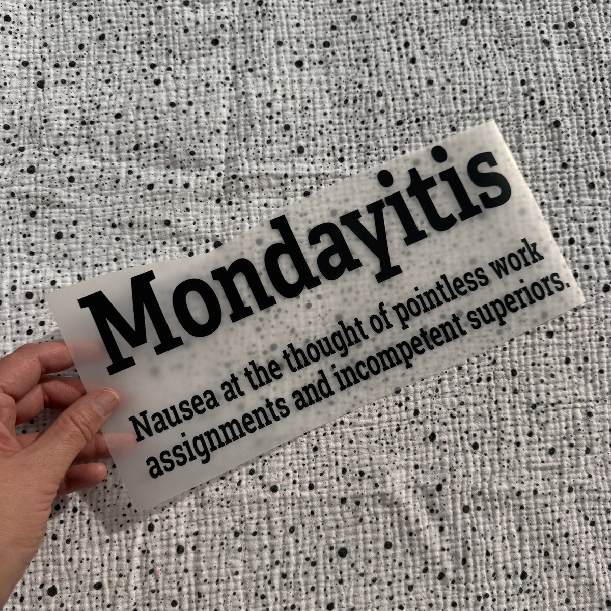 Bügelbild Mondayitis groß in Schwarz, ca. 29 x 12,5 cm, in der Hand gehalten
