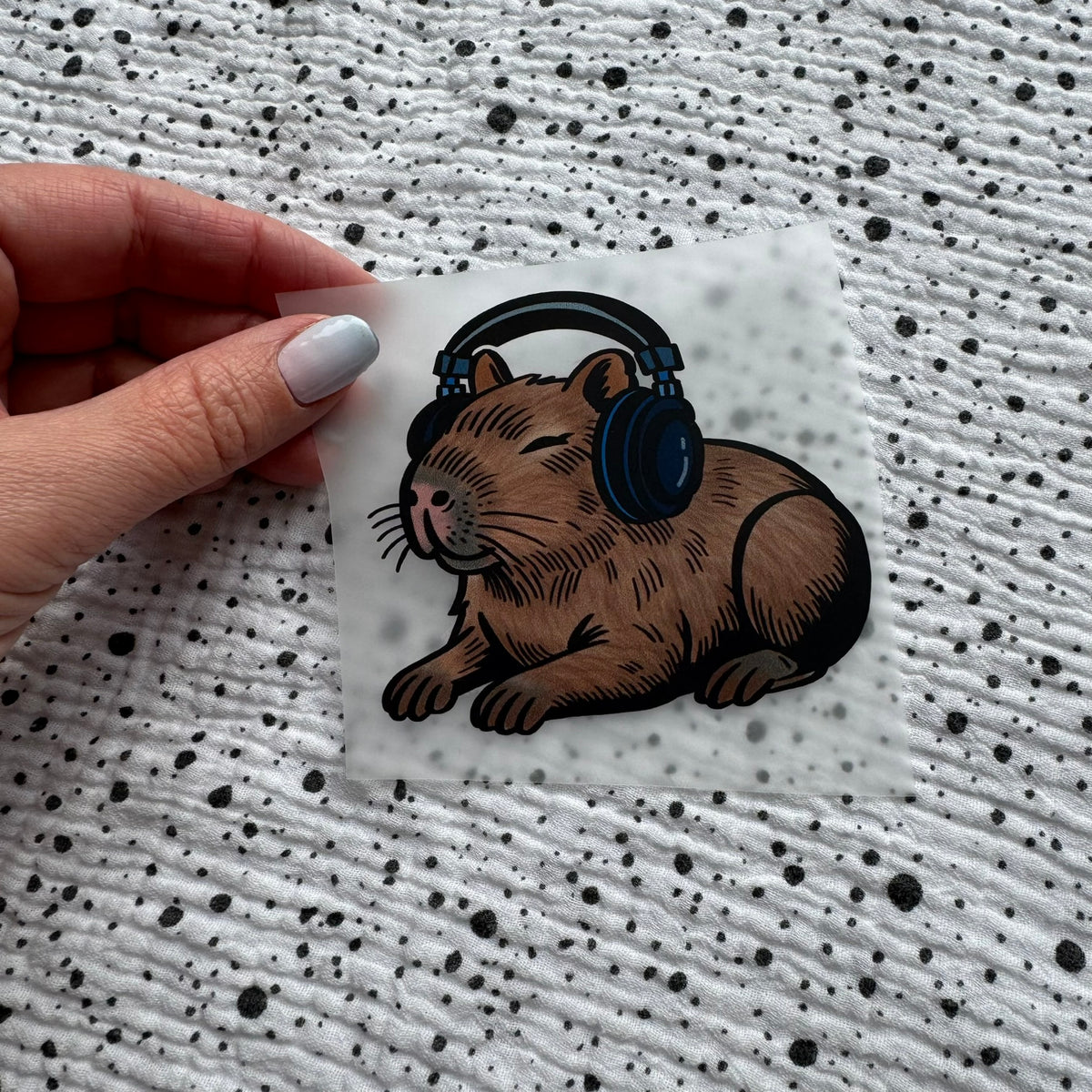 Bügelbild Music Capybara klein – Capybara mit Kopfhörern, in der Hand gehalten