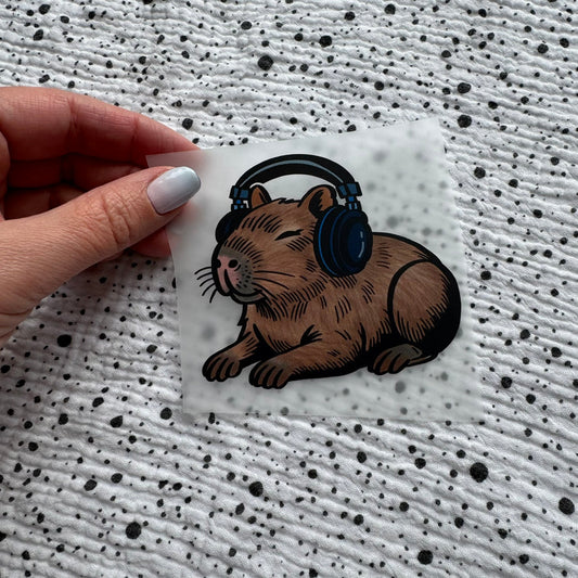 Bügelbild Music Capybara klein – Capybara mit Kopfhörern, in der Hand gehalten