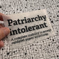 Bügelbild Patriarchy intolerant klein in Schwarz, ca. 10 x 6 cm, in der Hand gehalten