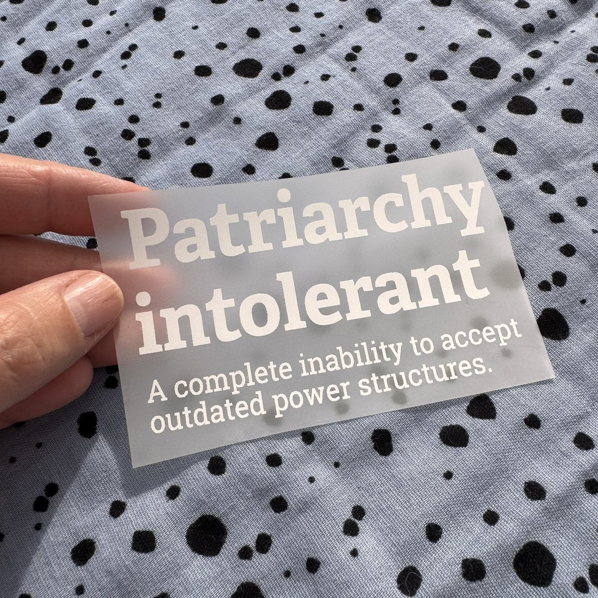 Bügelbild Patriarchy intolerant klein in Weiß, ca. 10 x 6 cm, in der Hand gehalten