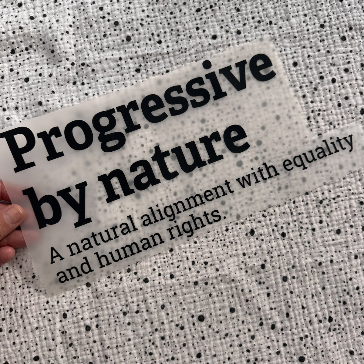 Bügelbild Progressive by nature groß in Schwarz, ca. 29 x 14 cm, in der Hand gehalten