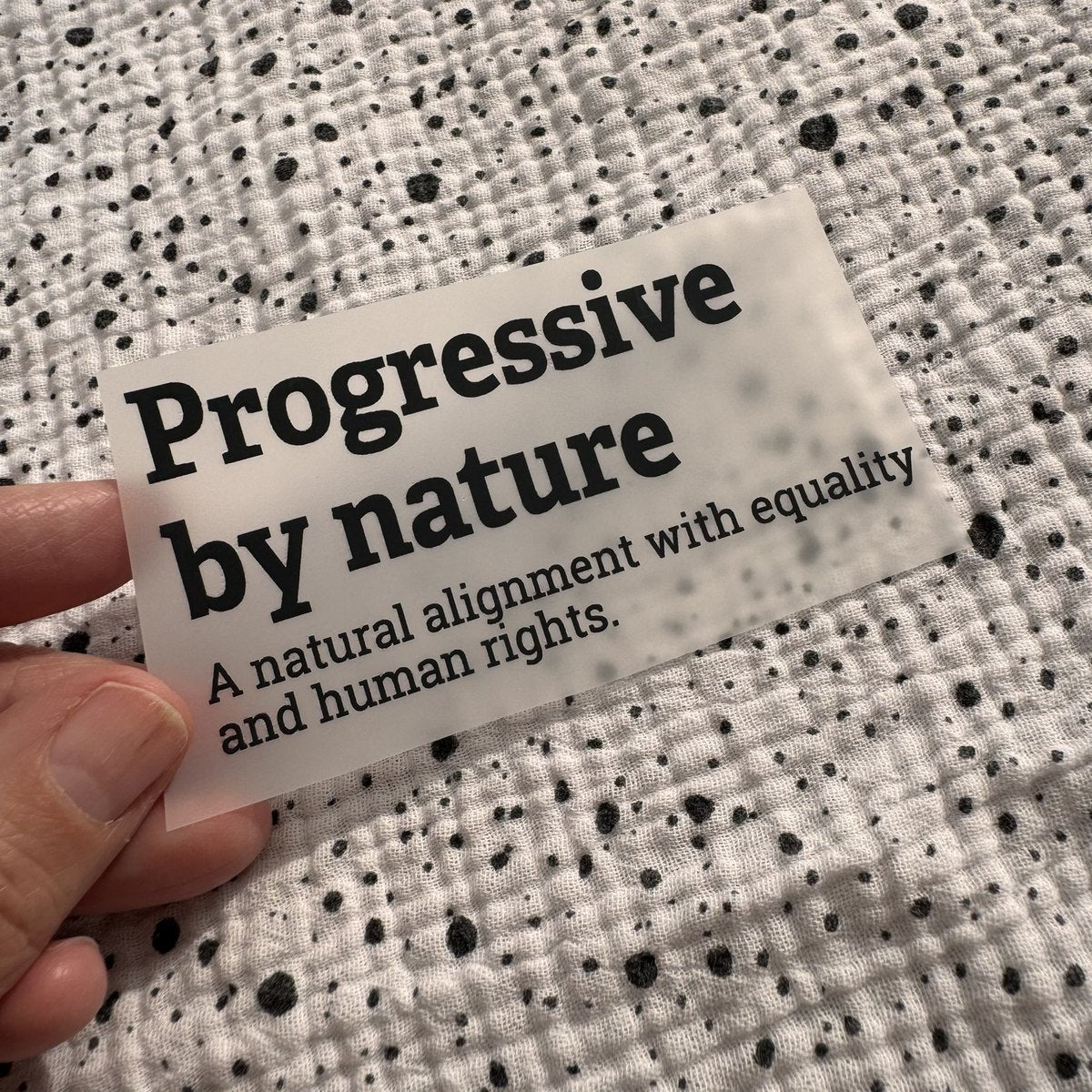 Bügelbild Progressive by nature klein in Schwarz, ca. 9,5 x 4,5 cm, in der Hand gehalten