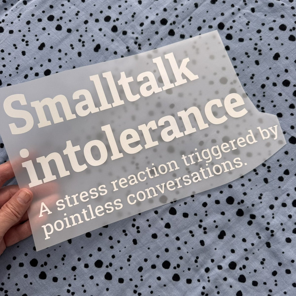 Bügelbild Smalltalk intolerance groß in Weiß, ca. 29 x 16 cm, in der Hand gehalten