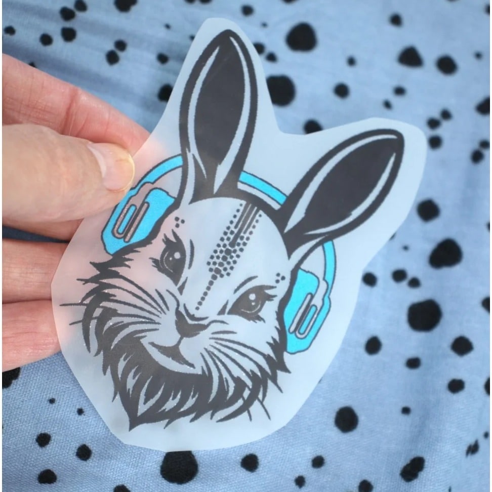 Bügelbild Sound Bunny Dad Mini – Hasenkopf mit türkisen Kopfhörern, in der Hand gehalten