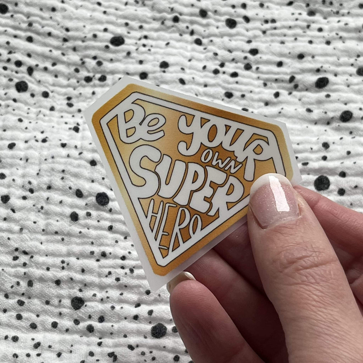 Bügelbild Super Hero in Gold – Superhelden-Wappen, in der Hand gehalten