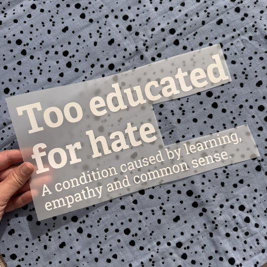 Bügelbild Too educated for hate groß in Weiß, ca. 29,5 x 15 cm, in der Hand gehalten