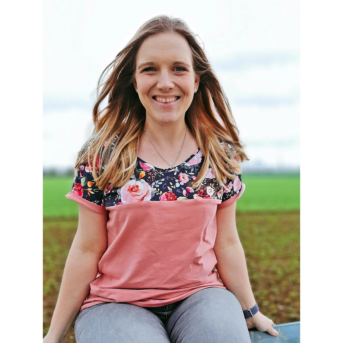 Lächelnde Frau im Family Shirt Damen im Colorblock aus dunklem Blumenstoff und altrosa Jersey mit angenähtem Ärmelaufschlag
