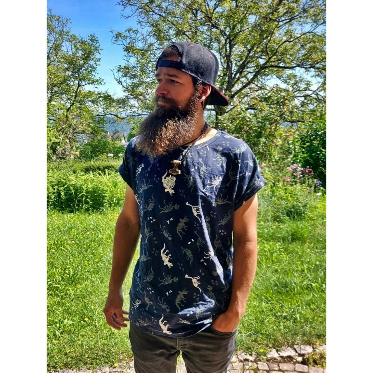 Mann mit Cap und Bart im dunkelblauen Family Shirt Herren mit Dino-Skelett-Print und angenähtem Ärmelaufschlag