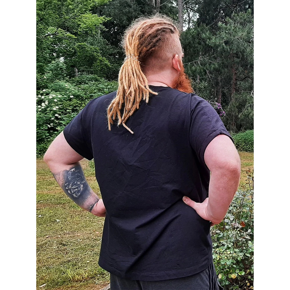 Rückansicht eines Mannes mit Dreadlocks im schwarzen Family Shirt Herren