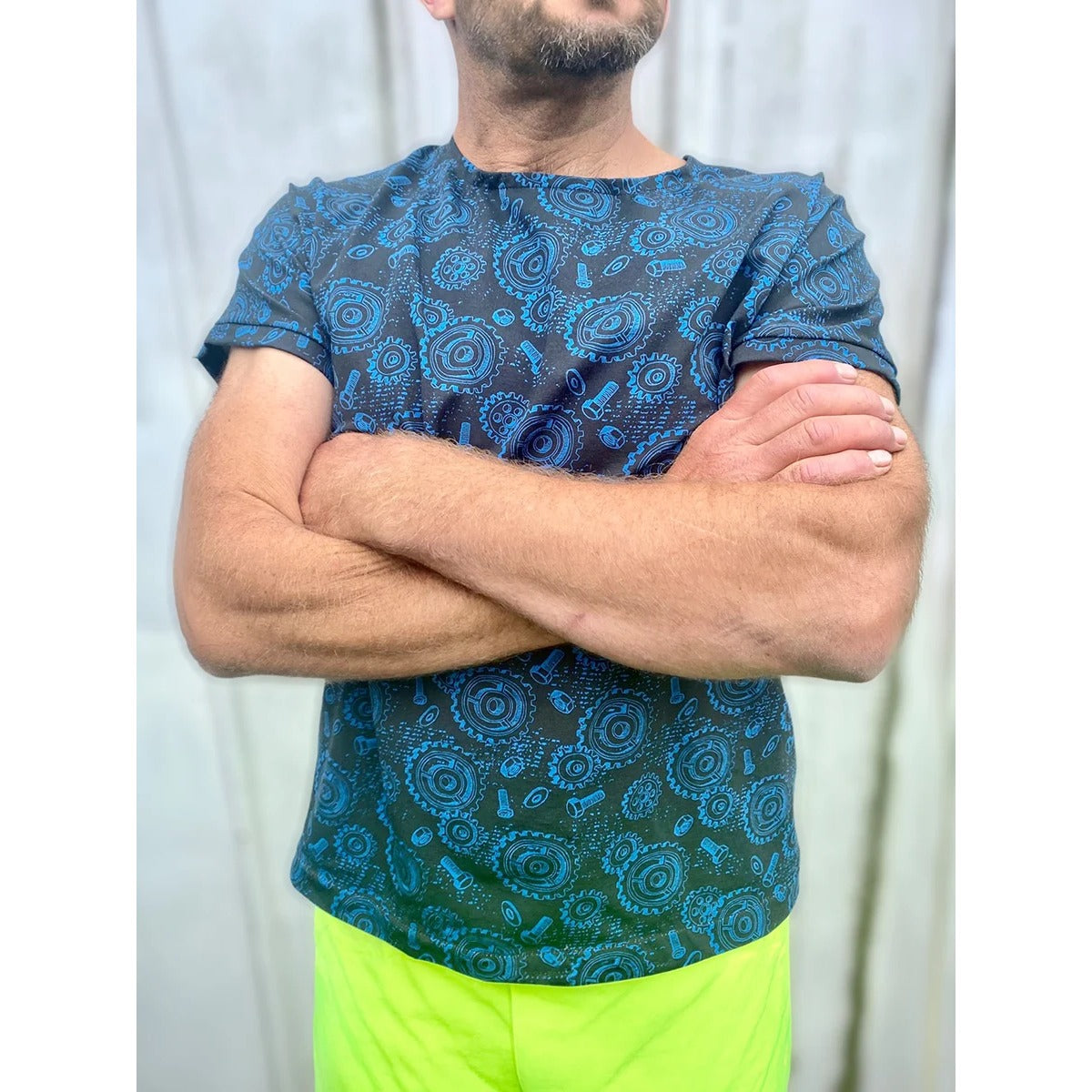 Mann im Family Shirt Herren mit blauem Zahnrad-Print, Arme verschränkt mit angenähten Ärmelbündchen aus dem selben Stoff